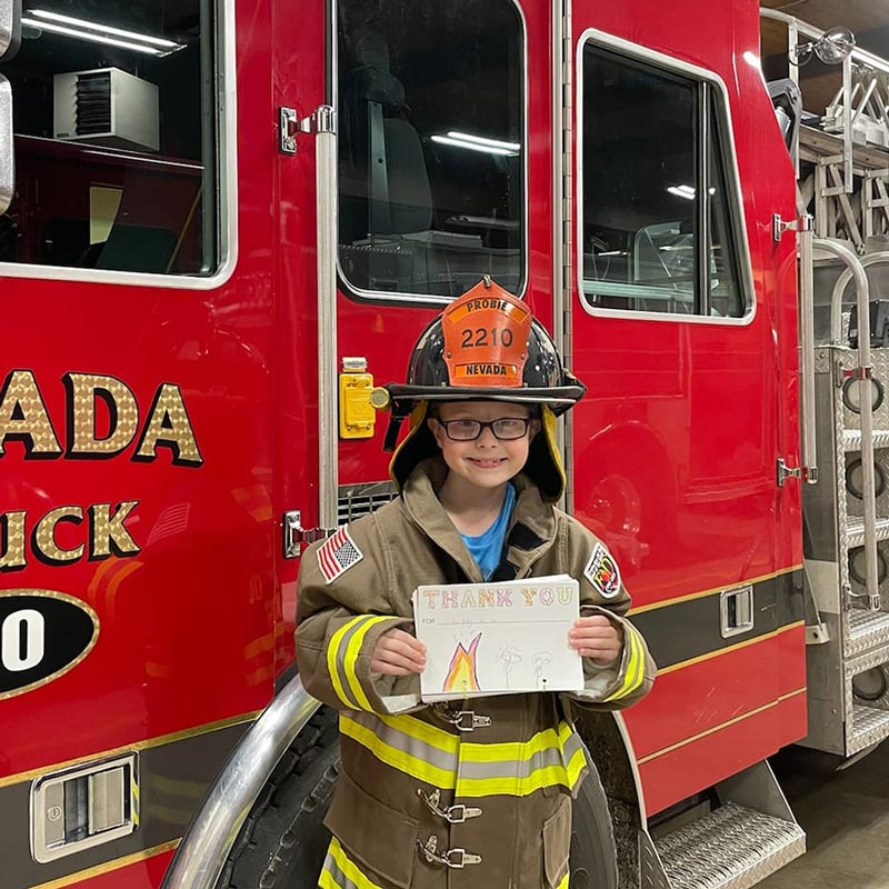 Young boy dressed as a firefighter at fire station