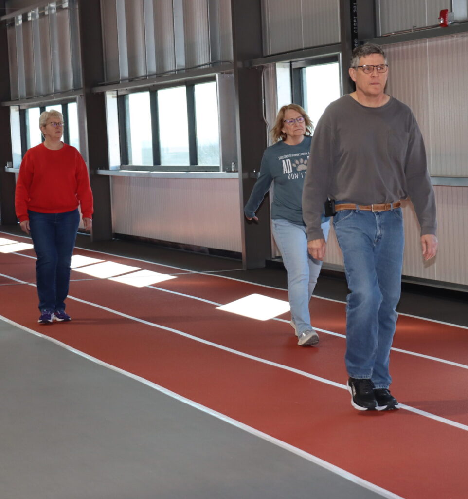 Walk With Ease participants walk along the track in the upper level of the Field House