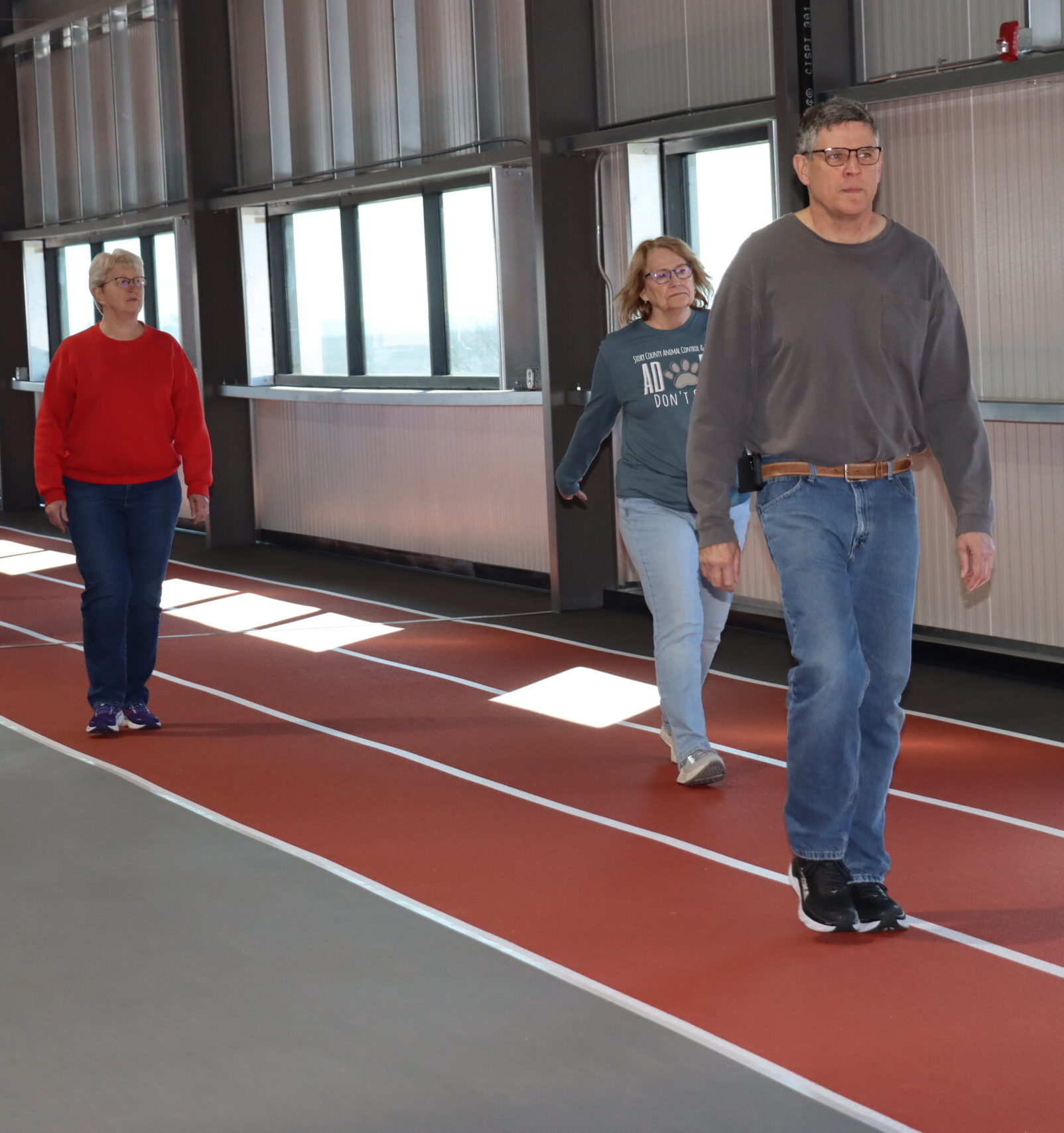 Walk With Ease participants walk along the track in the upper level of the Field House