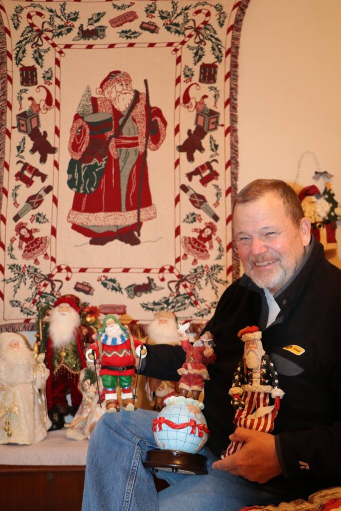 Mike Foley poses with several items in his Santa collection