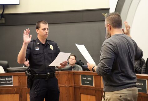 Officer Sean Seymour is shown taking the oath to become a sergeant from Mayor Brett Barker