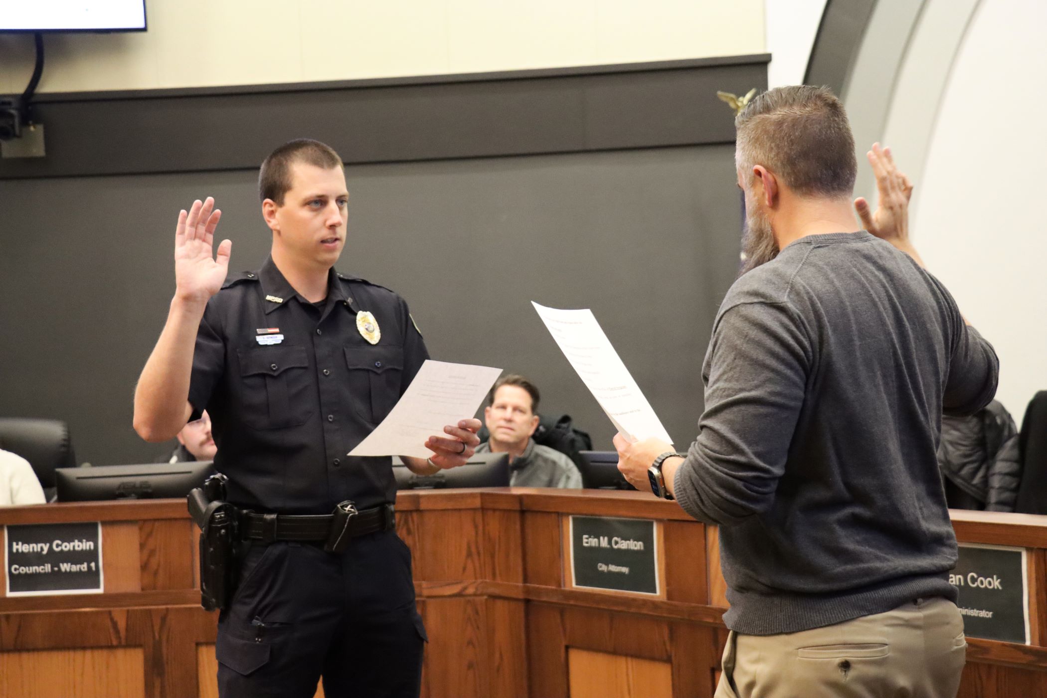 Officer Sean Seymour is shown taking the oath to become a sergeant from Mayor Brett Barker