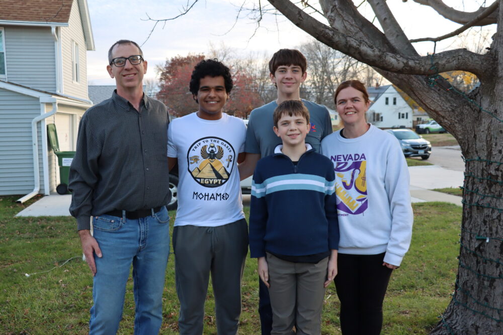 The Angus family is pictured with Mohamed in their front yard.