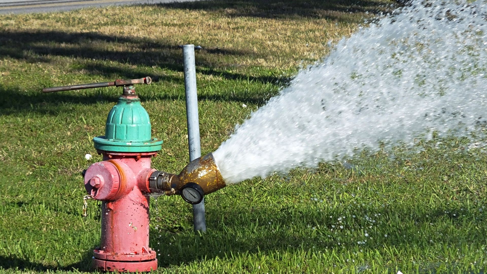 A hydrant being flushed is shown with water spraying out.