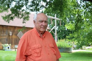 Loren Book pictured at his farm with a barn in background