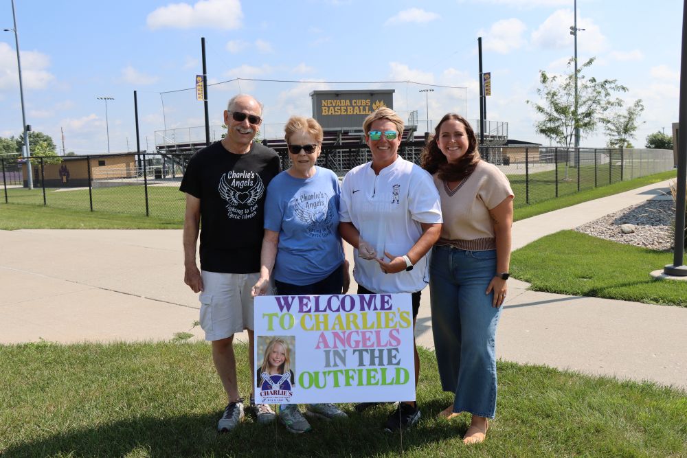 Shown are (from left) Reed and Lynn-Marr Moore, Parks and Rec Director Rhonda Maier, and Kelsey White, Executive Director of the Cystic Fibrosis Foundation, Iowa Chapter, all standing in front of the Nevada High School baseball field at SCORE.