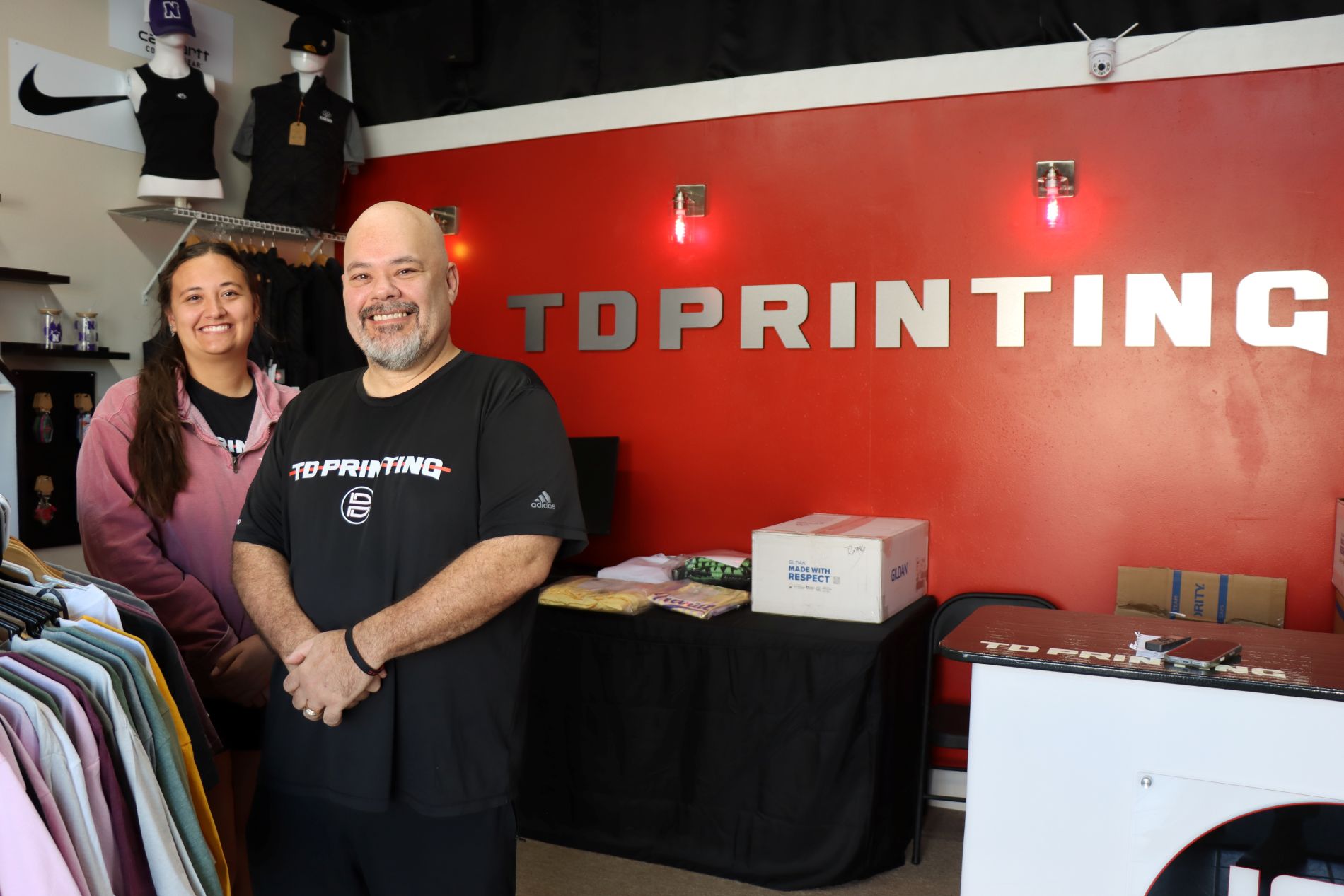 Tony Dunson and his daughter MacKenzie are pictured in the front of the printing business.